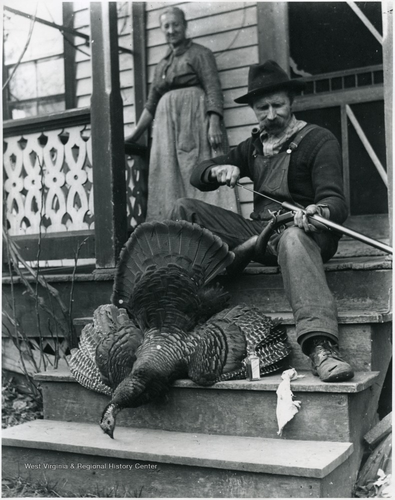 Gottfried cleaning out his gun by a dead turkey while Marianne Aegerter is watching.  Helvetia, W. Va.