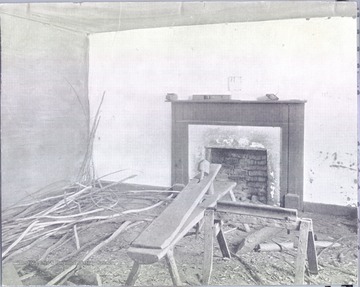 Interior of the deserted room in which Stonewall Jackson died, Guinea Station, VA. Fireplace, saw horse and scattered pieces of wood are visible.