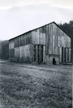 Exterior view of the tobacco barn constructed by Mr. A. C. Curry in Lincoln County. 'Narrow Ventilation doors which were opened in the front of the barn for this picture are located on all four sides of the barn. The barn is 50 feet wide, 60 feet long and 41 feet to the roof at the center of the barn.'