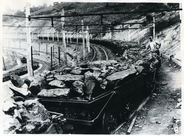This trip of loaded cars contain mine run coal, ready to be dumped, that 'White Oak' is proud to put its trade mark on as a stamp of approval. It has received every care in mining, shooting and transportation that can possibly be given any coal up to the point where it is ready to be sized and loaded into railroad cars. This coal, due to careful shooting, is not friable but firm and will handle in railroad cars through to destination with minimum of degradation.