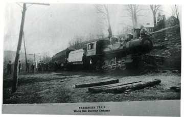 Passenger Train of White Oak Railway Co. with a line of people outside of it.