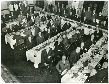 Lewis is seated at the table on the right.