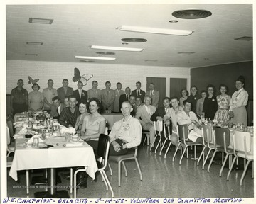 Group portrait of committee members standing and seated at tables during the W.E. Campaign, Volunteer Organization Committee meeting in Oklahoma City, Ok.