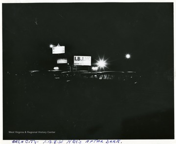 View of lights, signs, and cars parked at the I.B.E.W. Headquarters in Oklahoma City after dark.