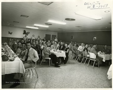 Group portrait of men and women seated at tables.