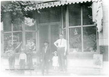 'Mr. Hogsett, proprieter, on right.'  Children and others in front of store.
