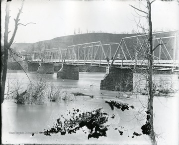 Two men standing on old iron bridge looking south.