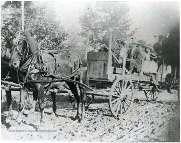 Lockard family members seated in wagon pulled by horses.