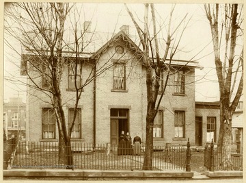 Sheriff Residence: 1896-1900 Facing Back Street now Washington Avenue. Three women standing in front of the house: Elizabeth Bond Lang (Wife John G. Lang) Etta Lang (Wife of F. Shuttleworth) Susan Hornor Lang (Wife of Sheriff Lq.L. Lang).