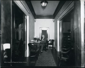 Interior view of the Bartlett home on McGraw Avenue in Grafton, W. Va. showing Col. Tom Bartlett working at his desk in the hallway.