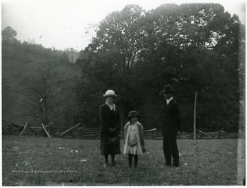 Olga Aegerter Holtkamp, Benjamin Holtkamp, and young girl standing in fenced in field area, Helvetia, W. Va.