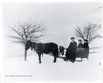 'In the sleigh right to left, Elka Hassig, Ernest Hassig, and Herman Schneider.'