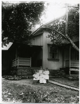 Four young children and a lady are standing in front of a porch of a house in Helvetia, West Virginia. 