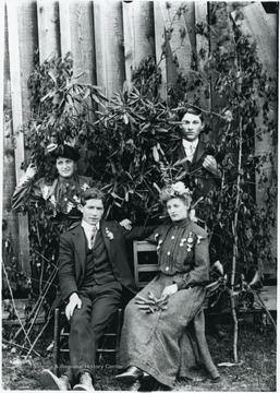 The two couples posed amongst shrubbery.