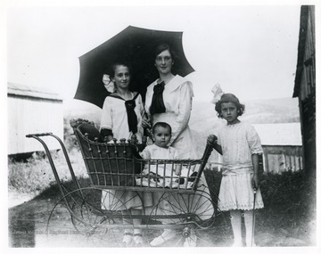 Standing from left to right: Ida Sutton, Anna Sutton, Elda Sutton, and Mable Sutton is the baby carriage.