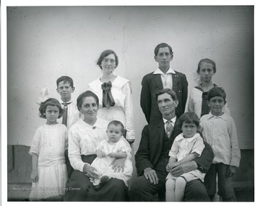 'The family of George and Bertha Teuscher Sutton. Left to right-Ida, Bill, Harley, Anna, Dave. Center row, Francis, Elda. Seated, Bertha with daughter Mable and George with son Edward. Taken on the occasion of Anna's birthday, October 07, 1918.'