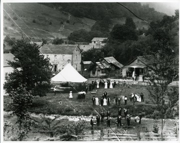 Inscribed on the back, "Showing the Star Band, horse-drawn 'swing' (merry-go-round), homes (l-r) Gottlief Datwlyer, cobbler shop, community store". 