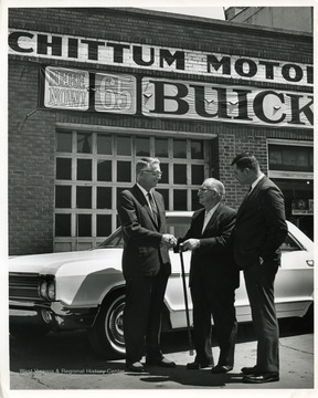 Image taken in fall of 1964; O. S. Chittum, owner of the Buick dealership, standing in center; other two men are Buick officials from the Pittsburgh zone office.