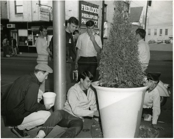 Male students painting a planter on high street.