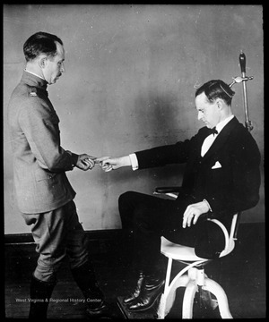 World War I Lantern Slide Show. Slide No. 05 in group of originally numbered slides. Physical examination of a recruit sitting in a chair. This is apparently a balance test for a potential pilot. Frame is labelled with text saying 'Visual Bureau, University of Pittsburgh.'  (negative no. 5-8237 is inscribed on slide)