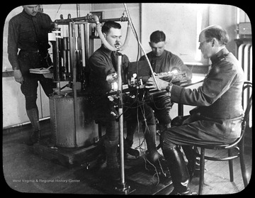 World War I Lantern Slide Show. Slide No. 07 in group of originally numbered slides. Physical examination of a recruit sitting in a chair breathing into a mask.  This is apparently a respiration test for a potential pilot. Frame is labelled with text saying 'Visual Bureau, University of Pittsburgh.'  (negative no. 7-19354 is inscribed on slide)<br /><br />