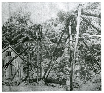 'The Volcano, Wood County oil fields, once the scene of fabulous supplies of oil, has become one of the ghosts areas of the county. The photo shows current operations at an old center, wherein an endless cable rolls over the wheels, driving the pumping mechanism for 25 wells in a large area.'