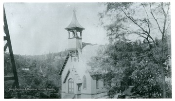 'The Episcopal Church that Red Neck Nellie helped to build. This picture was taken from an oil well derrick, another can be seen on the left, and at least 15 others are in the background.'