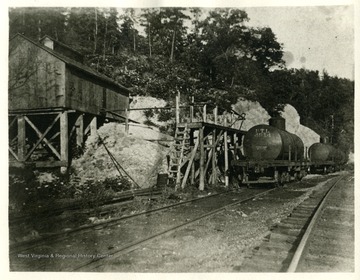 'Tanks and loading rack at Volcano Junction. Here the Sand Hill and Laurel Fork Railroad met the Baltimore and Ohio. Both standard gauge tracks.'