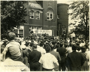 Crowds gather on the Courthouse Square to see Governor Wally Barron and actor Don Knotts who are standing at the podium.