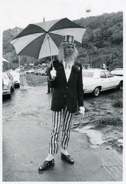 Man dressed as Uncle Sam holding a umbrella. 