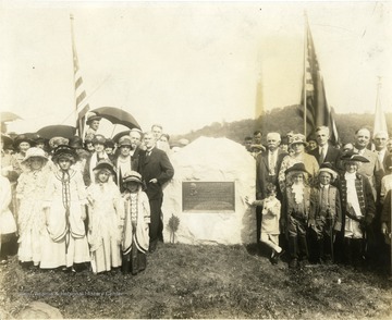 'Dedication and Unveiling of Monument at Pricketts Cemetery in Marion County, in memory of Colonel Zackquill Morgan and wife Drusilla. Boy standing with hand on monument and other hand to his nose is George M. Barrick, Jr., a direct descendant of Colonel Morgan, also took part in the unveiling. Date, Sunday, September 11, 1927. In the foreground pack of children on the right: Mr M. W. Harris, chairman of Monument Committee, Mrs. E. A Grose (Morgan), Max Mathers, Chairman of Program Committee. Roy Jake, speaker for the occasion of Dedication, Mr. Kerr. On the left, Dr. M. C. Kelley, representing Monongalia Historical Society. Back of Dr. Kelley, Earl Morgan (dedicatory address). Above in the names of the children who participated in unveiling of monument this data written by: Max Mathers, February 26, 1957.'