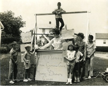 A group of children and two women stand near their own personal concession stand. Proceeds were donated to Muscular Dystrophy foundations. 
