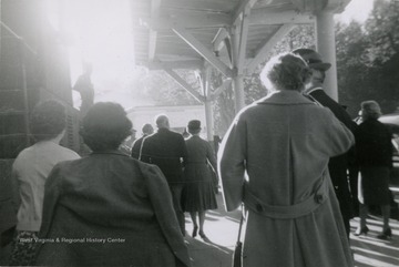 People gather for Dwight D. Eisenhower's visit to Hot Springs.  Ike and Mamie Eisenhower walking away from camera in distance in center of photo.