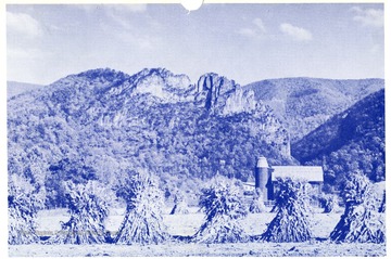 'A typical West Virginia farm scene with majestic Seneca Rock in the back-ground.  Located on U.S. Route No. 33 in Pendleton County.  Emmett Carmichael, Agent, Wellsburg, W.Va.'