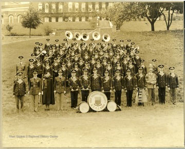 WVU Band on old athletic field, and Women's Hall in the background. This location is now where the parking garage is located. '1st row left to right: 1. Director Walter Mestrezat, 3. Jane Green, 6. William (Ray) Broderick, and 14. Bernard McGregor. 2nd row left to right: 22. Edward Eilaud, and 23. Mack Allison. 5th row left to right: 47. Harold Case'