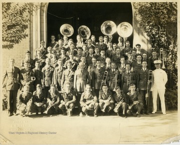 'Left to right, beginning first standing,1. Drum Major, 3. Cal Jacobson, and 6. Paretto Mascioli(?) 2nd row left to right: 10. Samuel Clark(?)14. Walter Mestrezat, Director, and 20. Cal Harry Shelton. 3rd row left to right: Robert Bayles, 24. Junior Macintire, 26. William Broderick, 27. Bernard McGregor and 29. Nathan Hall. 4th row left to right: Wilson Poole Shartidge, and 36. William Barker. 6th row left to right: 49. John Cole, and 50. Walter Cole.'   