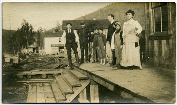 'Left to right: Charles W. Feeny, W. W. Burton(?), Marline E. Brown, boys, D. D. Brown, Marie Stevens. Calvin Stevens, and Mrs. Walter Stevens.'