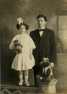 The young girl holding a teddy bear is Frances Davenport Packette. The older boy is possible her brother, Willie.