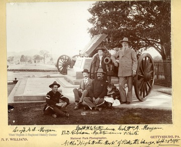 Pictured around a cannon: U. S. Sergent A. S. Morgan; U. S. Captain H. C. Getzendanner; Former Confederate Colonel W. A. Morgan; B. D. Gibson; Mrs, Getzendanner; and unidentified small boy.