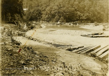 Postcard photograph of the flood damage along Cabin Creek including the railroad tracks in the background. Information on the back: "Hinton Daily News Collection - John Faulkner Collection From Jim Pettrey to Stephen Trail 1997". 