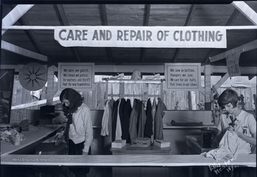 Two 4-H members demonstrate proper clothing care.