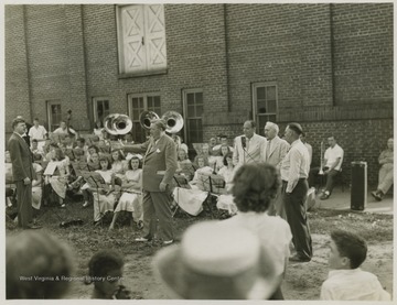 View from the audience, looking at a band comprised of young musicians outside Summers Memorial Building. Subjects unidentified. 