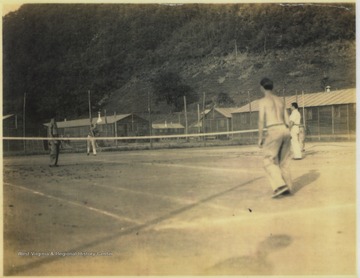 Members of the C.C.C. play a game of tennis. Stephen D. Trail, later an employee at Hinton Daily News, pictured shirtless on the right. 