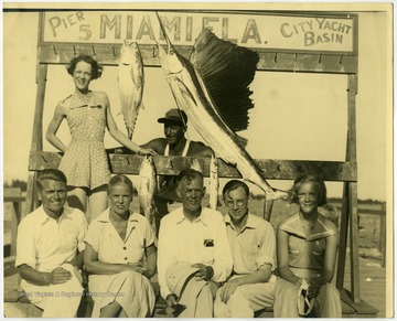 Young Maryat Lee, seated far right, with her father, seated in the center of the bottom row, and the Lamberts.Maryat Lee (born Mary Attaway Lee; May 26, 1923 – September 18, 1989) was an American playwright and theatre director who made important contributions to post-World War II avant-garde theatre.  She pioneered street theatre in Harlem, and later founded EcoTheater in West Virginia, a community based theater project.Early in her career, Lee wrote and produced plays in New York City, including the street play “DOPE!”  While in New York she also formed the Soul and Latin Theater (SALT), and wrote plays centered around the lives of the actors in the group.In 1970 Lee moved to West Virginia and formed the community theater group EcoTheater in 1975.  Beginning with local teenagers from the Governor’s Summer Youth Program, the rural theater group grew, and produced plays based on oral histories collected from the local community.  Each performance of an EcoTheater play involved audience participation and discussion.  With the assistance of the Humanities Foundation of West Virginia, guest scholars became a part of EcoTheater.