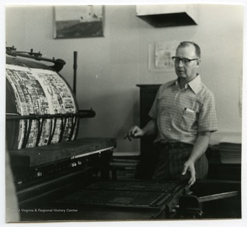 Woodrow "Woody" Wilson, owner of the Wirt County Journal in Elizabeth, W. Va., next to the linotype machine used for the newspaper.The photos in this collection were used in chapters that appeared in Mountain Trace, a publication of Parkersburg High School in West Virginia, edited by Kenneth G. Gilbert.